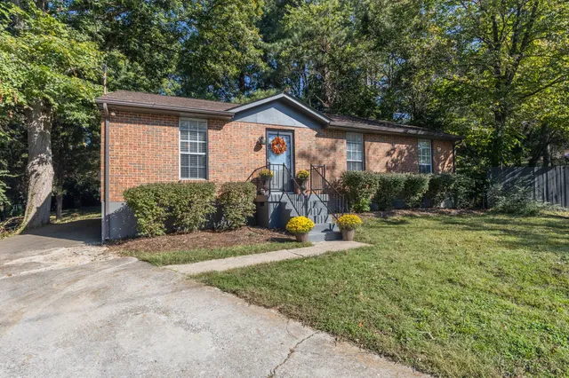 a view of a house with backyard and trees
