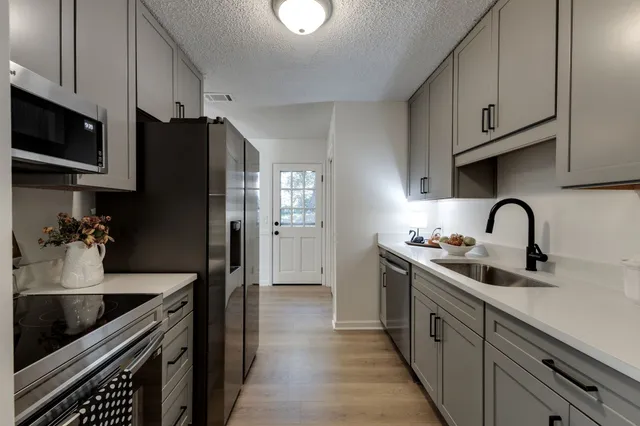 a kitchen with stainless steel appliances granite countertop a sink stove and refrigerator