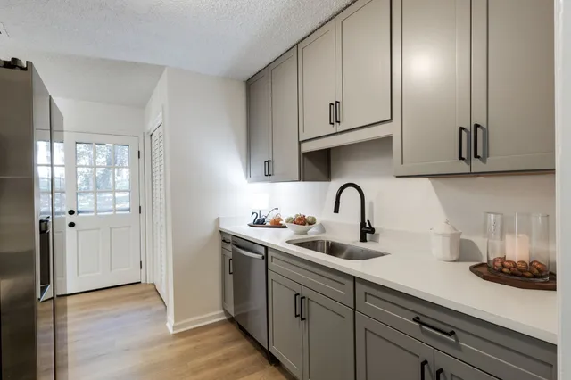a kitchen with stainless steel appliances granite countertop white cabinets a sink and dishwasher