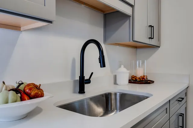 a kitchen with a sink and a stove with wooden floor