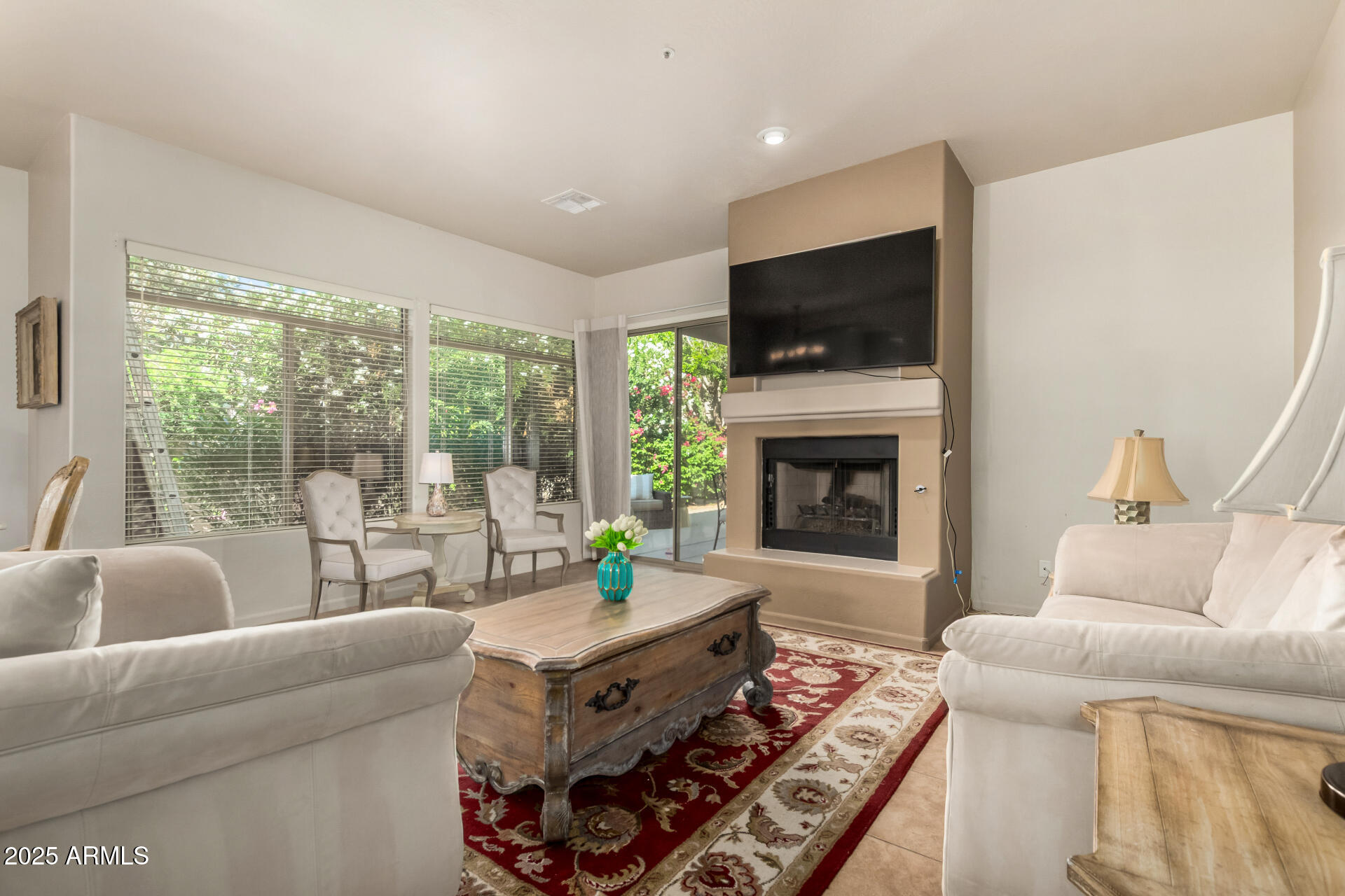 a living room with furniture a flat screen tv and a fireplace