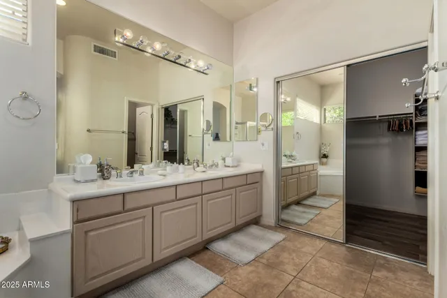 a bathroom with a double vanity sink mirror and shower
