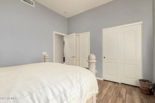 a bedroom with a bed and wooden floor