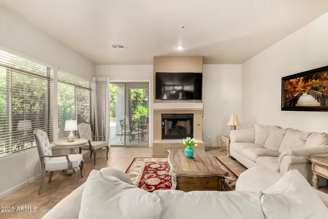 a living room with furniture a flat screen tv and a fireplace