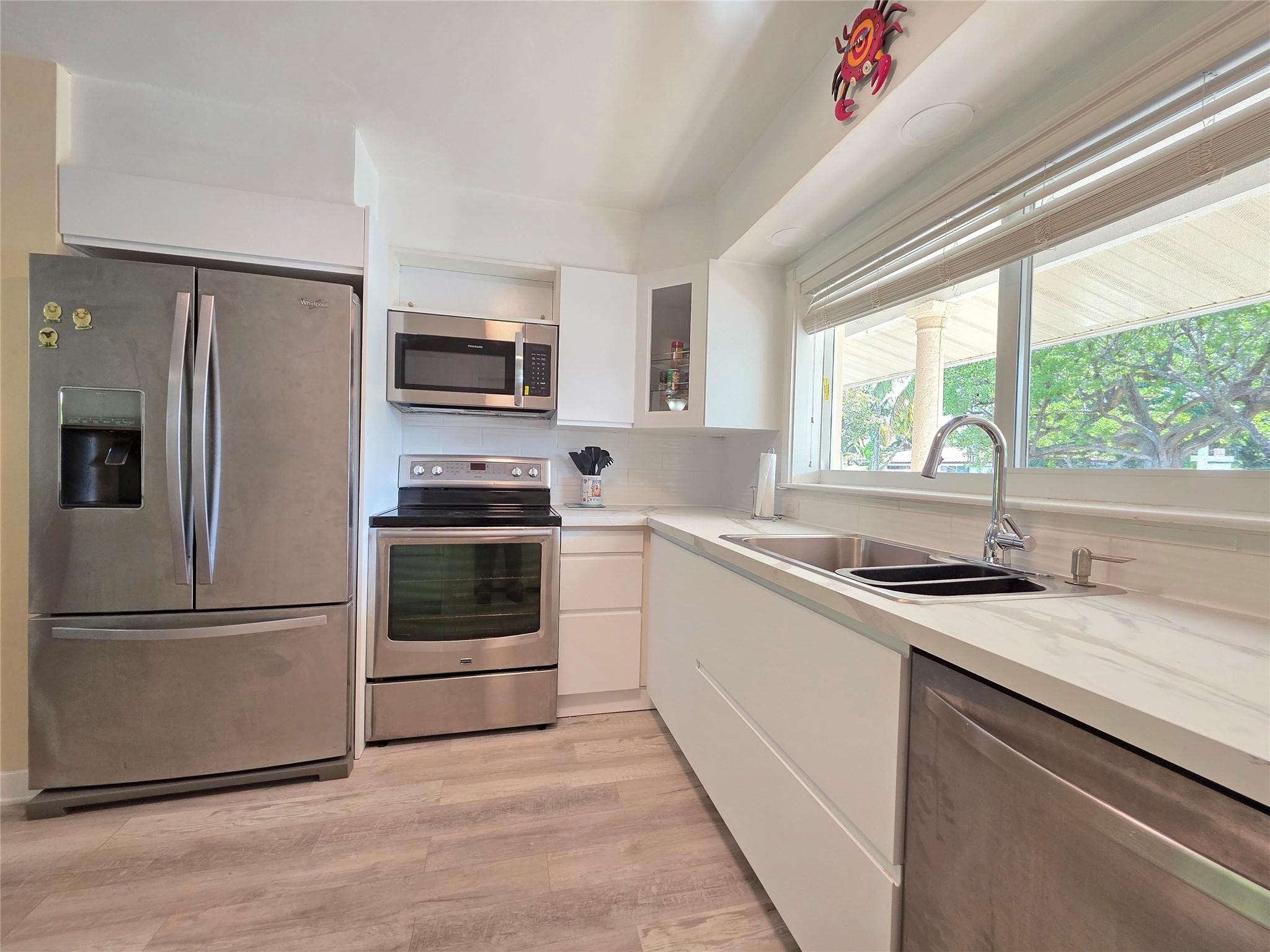 2585 Southeast 3rd Street Pompano Beach, FL 33062 - Photo 15 of 71 a kitchen with granite countertop a refrigerator and a sink