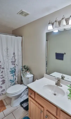 a bathroom with a sink mirror and toilet