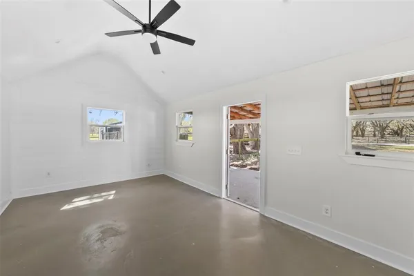 a view of a white house in the middle of a yard