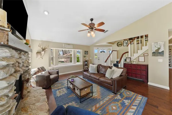 a kitchen with granite countertop a stove a sink a dining table and chairs with wooden floor