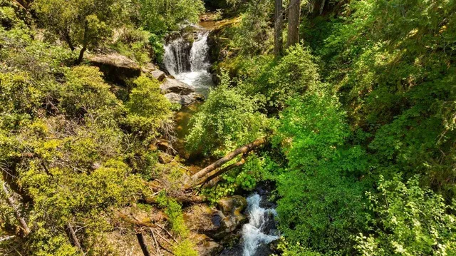 a kitchen with stainless steel appliances granite countertop a table chairs and a refrigerator