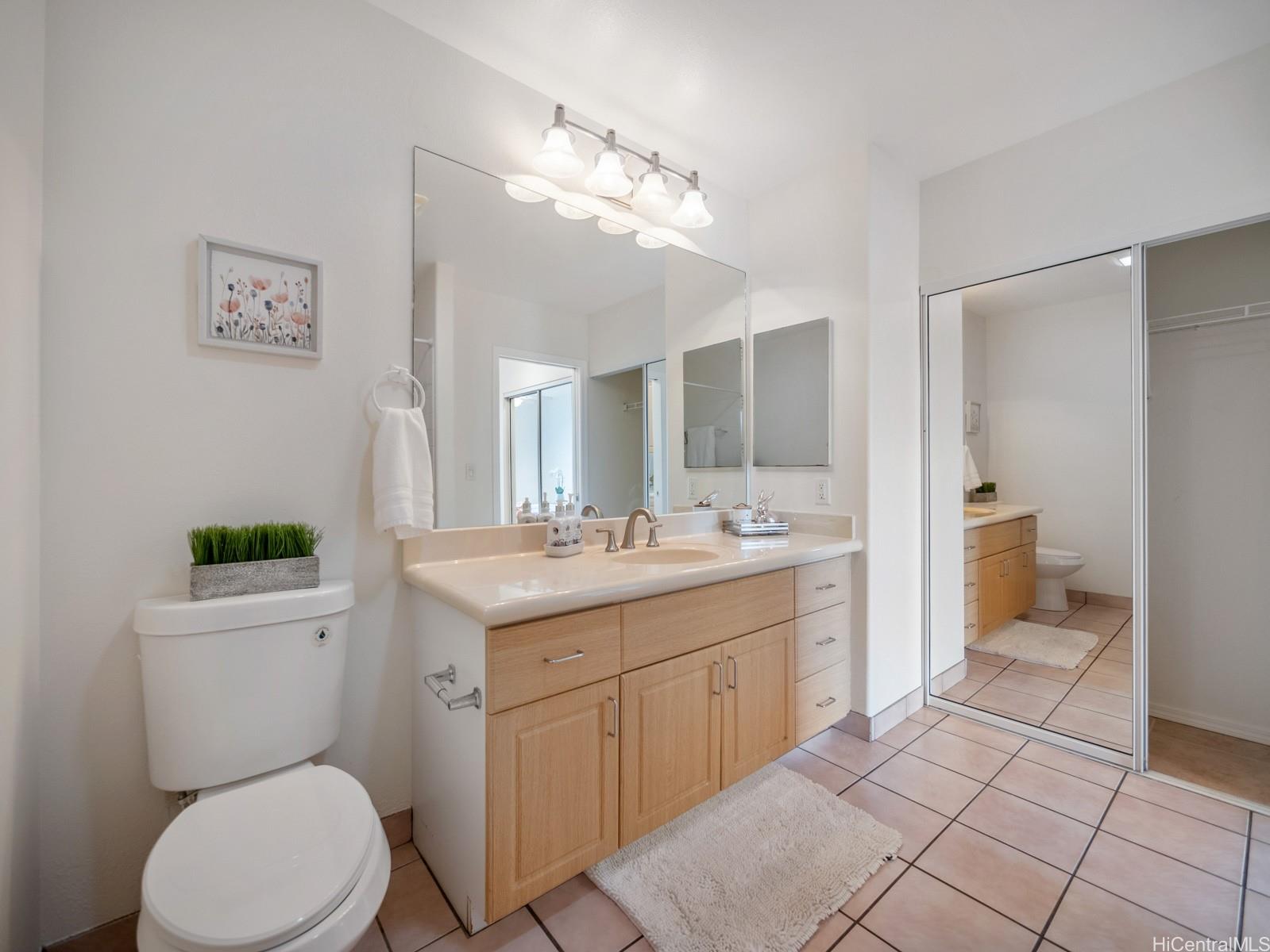 95-982 Wikao Street, Unit L203 Mililani, HI 96789 - Photo 15 of 25 a bathroom with a toilet a sink and mirror