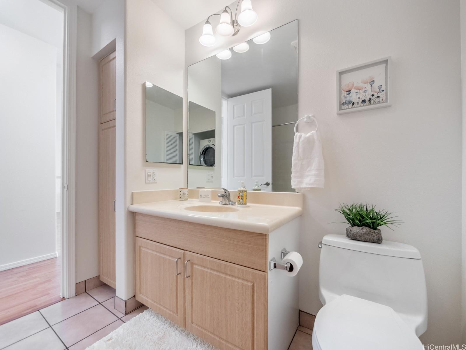 95-982 Wikao Street, Unit L203 Mililani, HI 96789 - Photo 20 of 25 a bathroom with a toilet sink and mirror