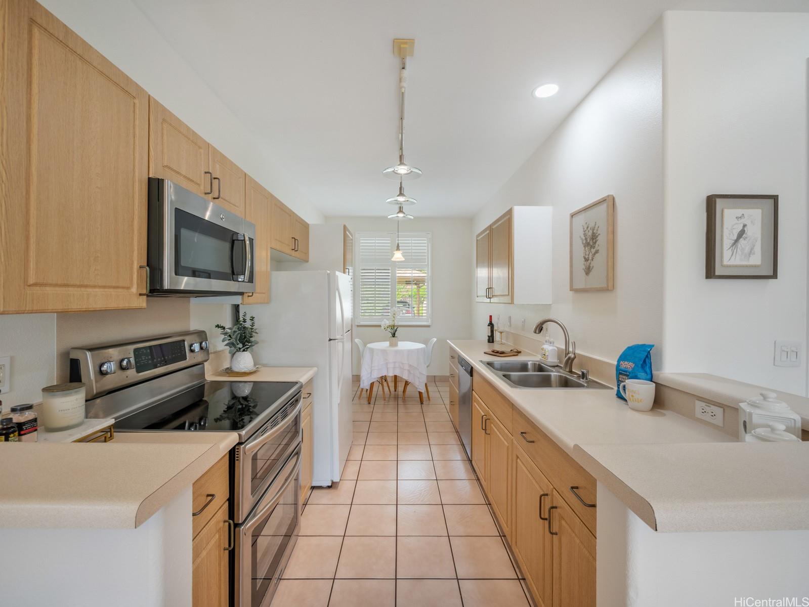 95-982 Wikao Street, Unit L203 Mililani, HI 96789 - Photo 5 of 25 a kitchen with stainless steel appliances a sink stove and cabinets