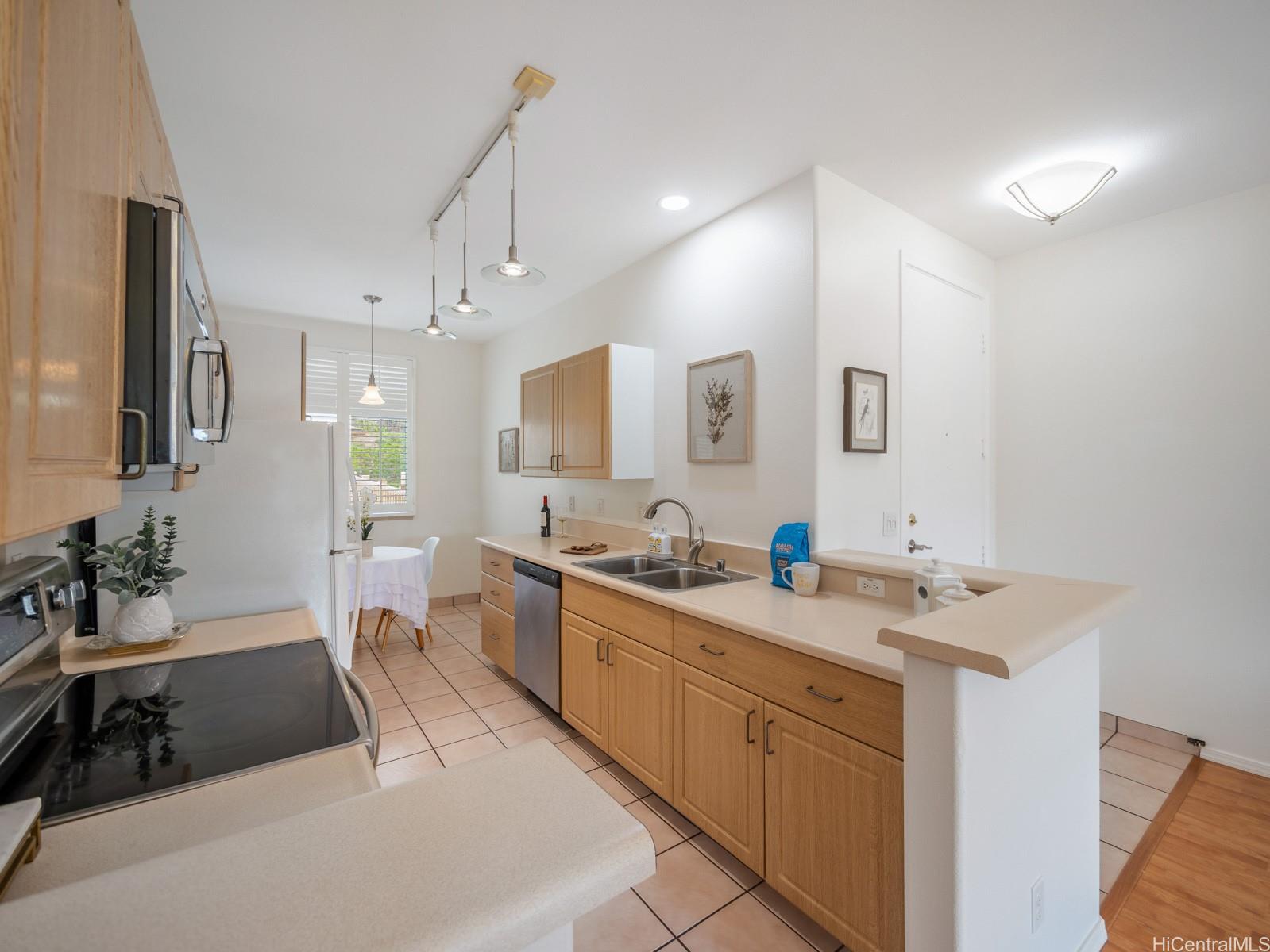 95-982 Wikao Street, Unit L203 Mililani, HI 96789 - Photo 6 of 25 a kitchen with a sink stove and cabinets