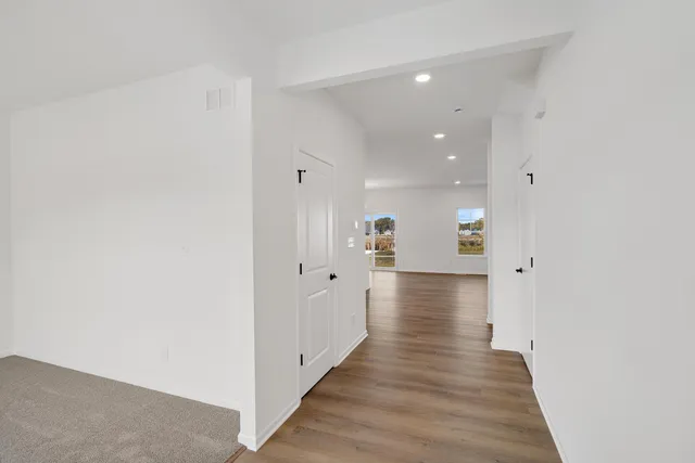 a view of a hallway with wooden floor