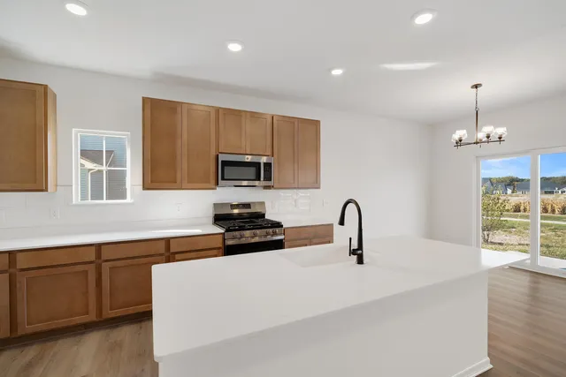 a kitchen with sink a microwave and cabinets