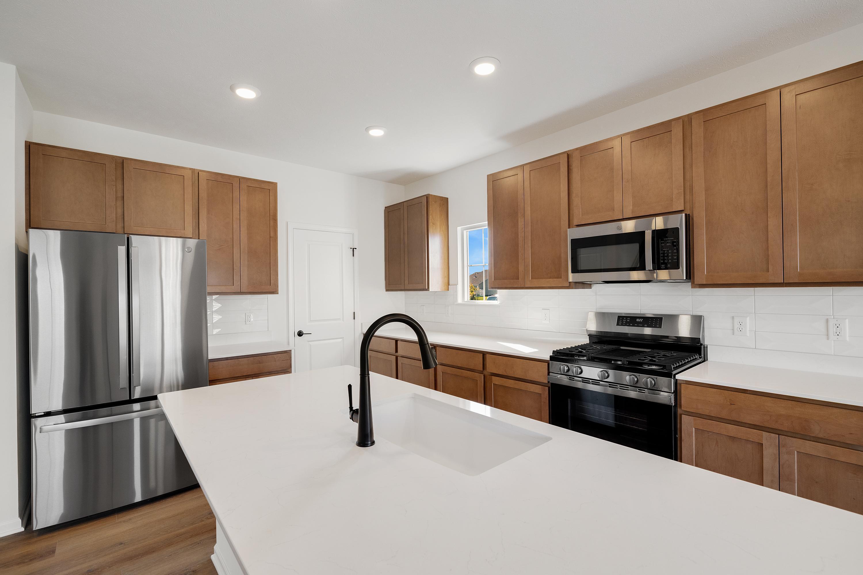 3980 Riverwood Road Valparaiso, IN 46385 - Photo 8 of 28 a kitchen with granite countertop a refrigerator stove and microwave