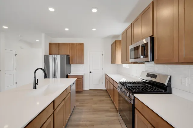 a kitchen with stainless steel appliances a sink a stove and a refrigerator