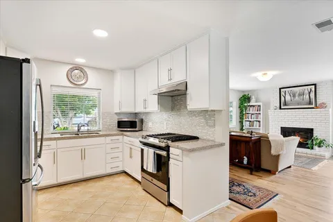 a kitchen with cabinets a window and a fireplace