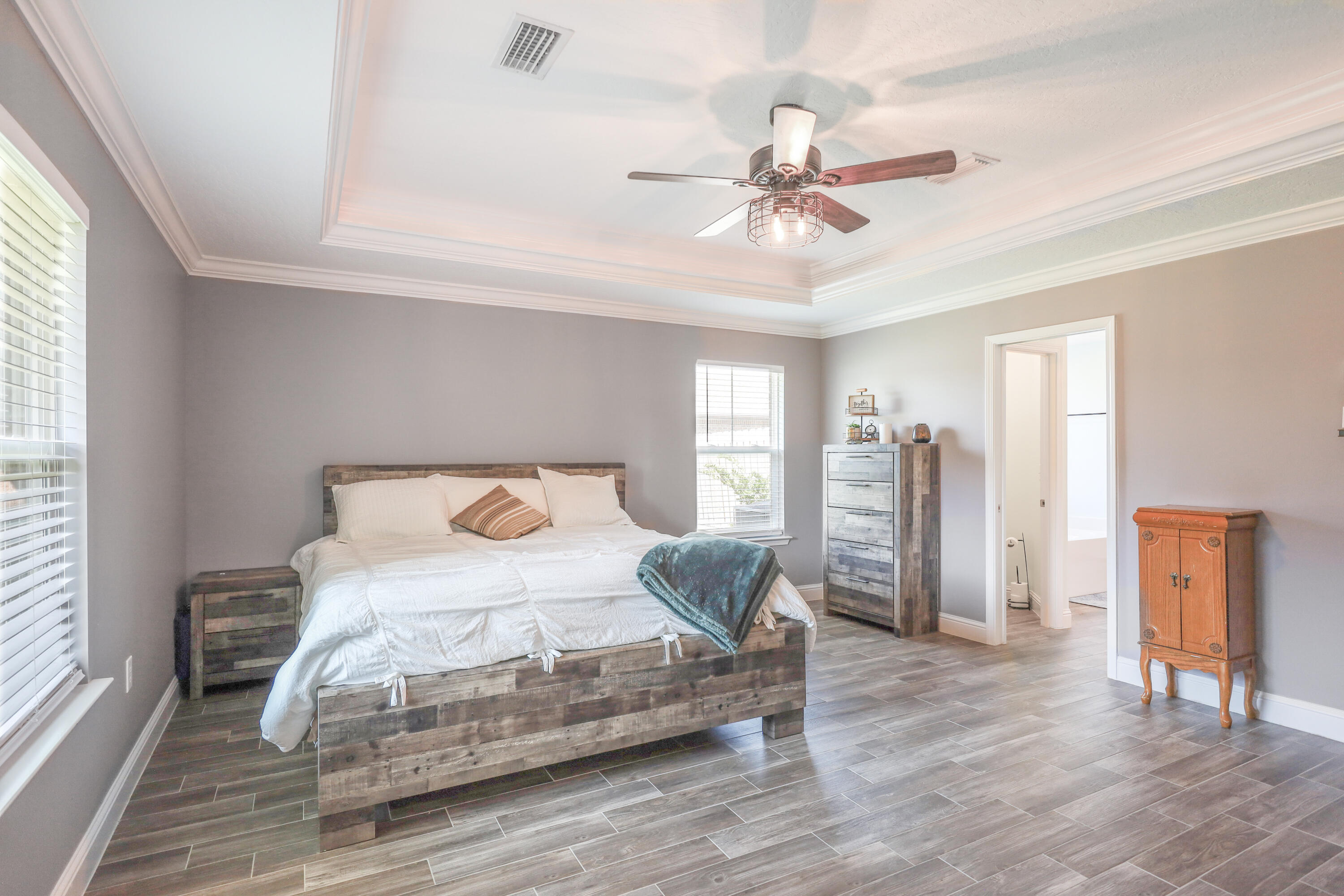 2896 Chancery Lane Crestview, FL 32539 - Photo 13 of 33 a bedroom with a large bed and wooden floor
