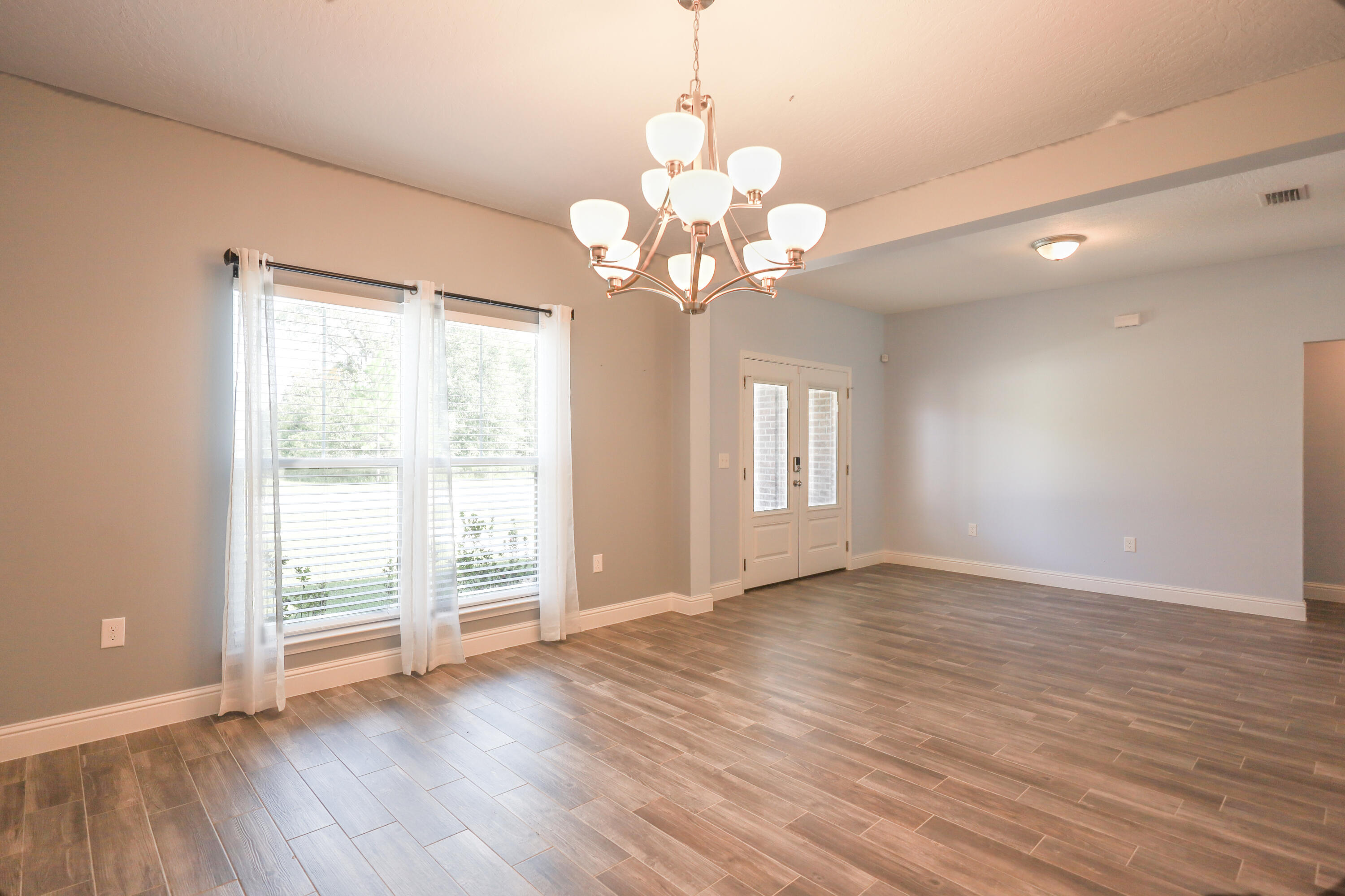 2896 Chancery Lane Crestview, FL 32539 - Photo 3 of 33 a view of an empty room with wooden floor and a window