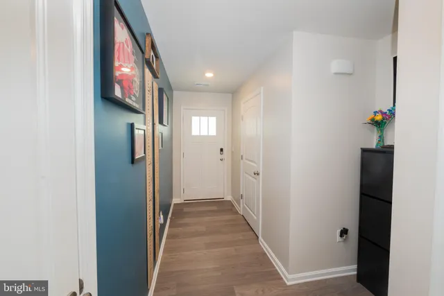 a view of a hallway with wooden floor and windows