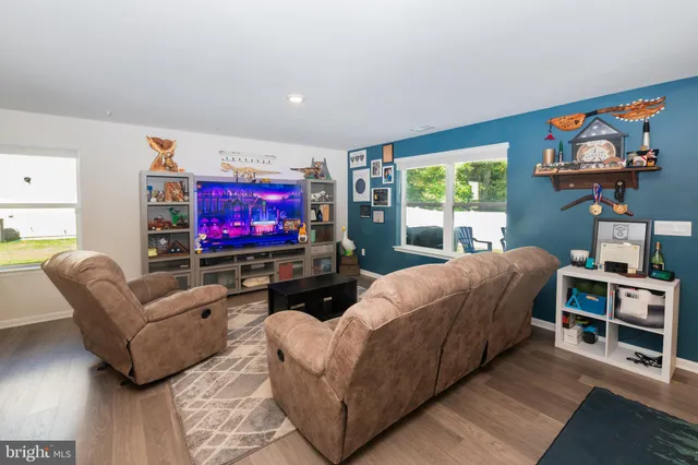 a living room with furniture a flat screen tv and a floor to ceiling window
