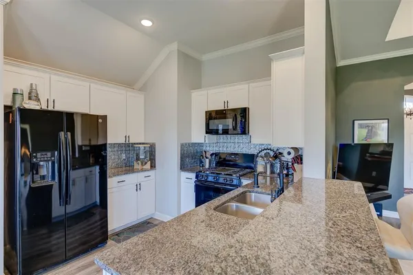 a kitchen with stainless steel appliances granite countertop a refrigerator stove and sink