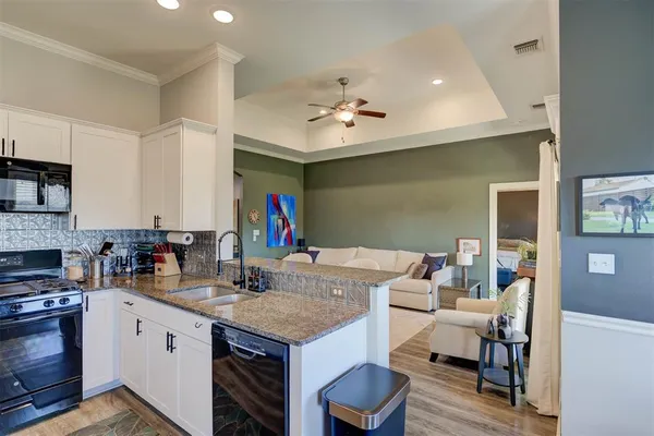 a kitchen with granite countertop a sink appliances and cabinets