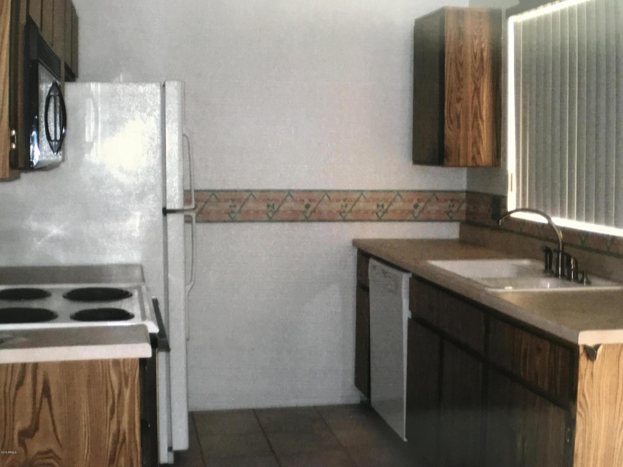 1738 East Grandview Road Phoenix, AZ 85022 - Photo 5 of 15 a kitchen with a sink and a refrigerator
