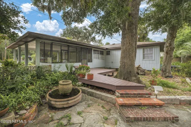 a backyard of a house with fountain table and chairs