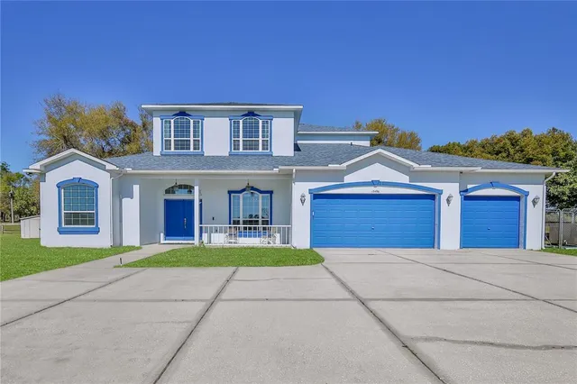 a view of house with a big yard and large trees