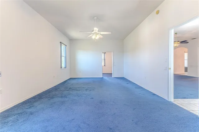 a front view of a house with swimming pool and large trees