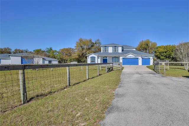 an empty room with chandelier fan and windows