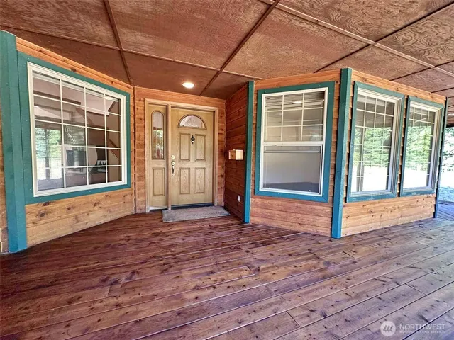 a view of empty room with wooden floor and floor to ceiling window