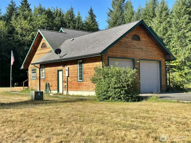 a front view of house with yard and trees around