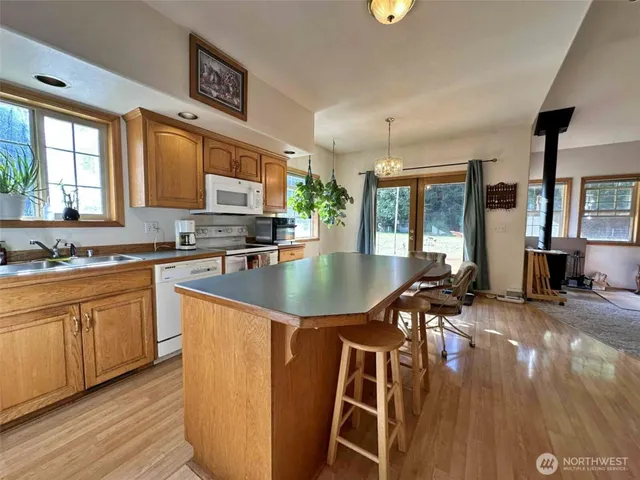 a kitchen with stainless steel appliances granite countertop a sink a stove counter space and living room view