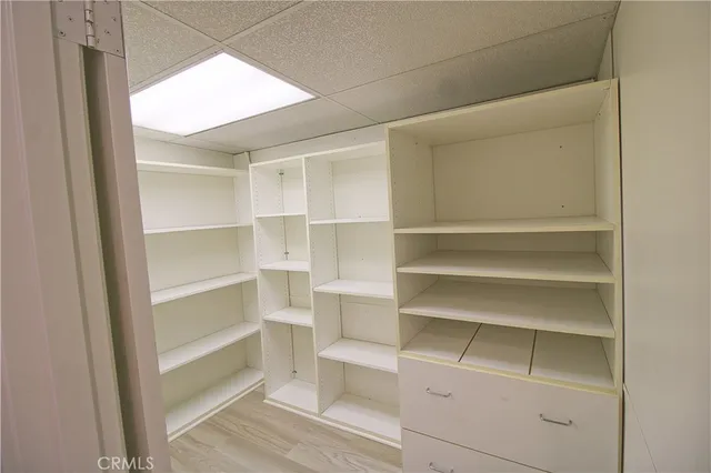 a view of walk in closet with empty racks