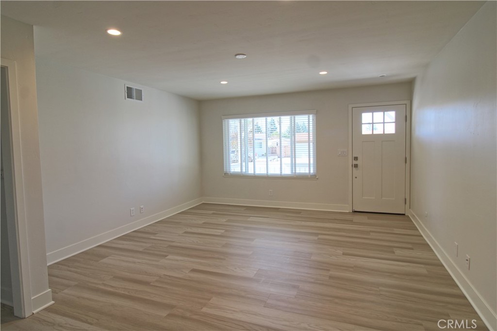 34464 Avena Way Yucaipa, CA 92399 - Photo 3 of 17 an empty room with wooden floor and windows
