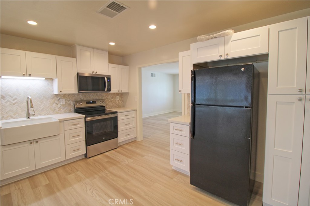 34464 Avena Way Yucaipa, CA 92399 - Photo 6 of 17 a kitchen with a refrigerator a stove top oven a sink and dishwasher