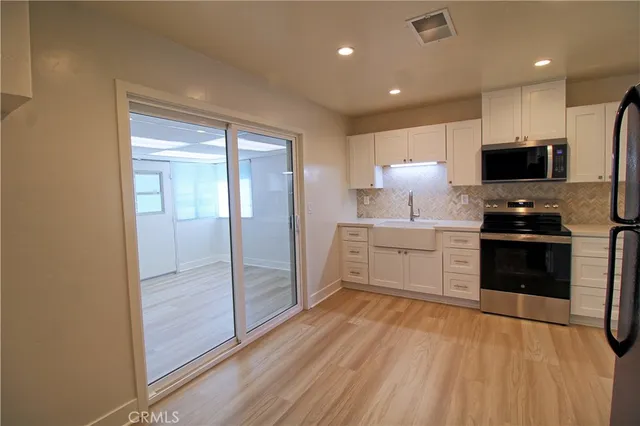 a kitchen with stainless steel appliances a refrigerator and a stove top oven