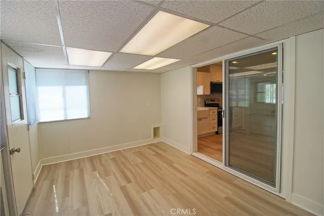 a view of an empty room with window and wooden floor