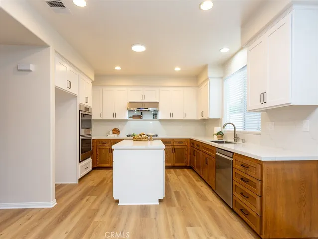 a kitchen with stainless steel appliances a refrigerator sink and cabinets
