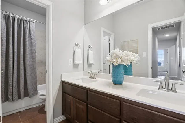 a bathroom with a double vanity sink and a mirror