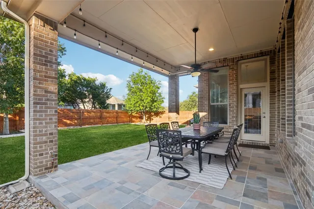 a view of a patio with a table chairs and a yard