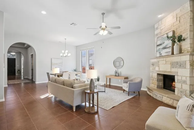 a living room with furniture a fireplace and a chandelier