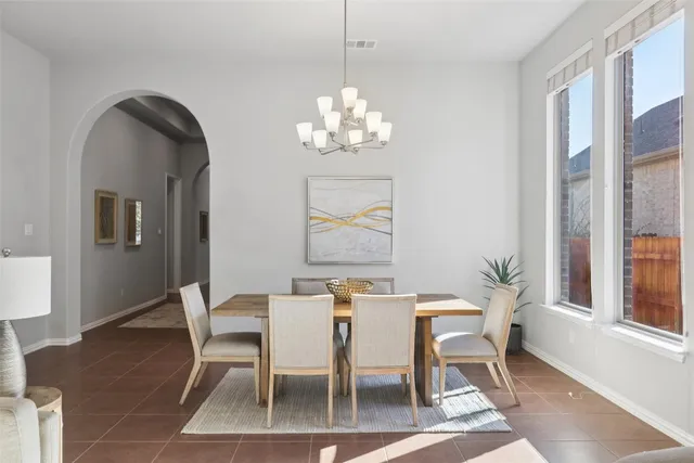 a view of a dining room with furniture a chandelier and wooden floor