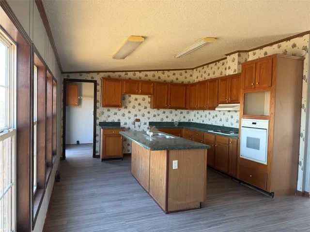 a kitchen that has a lot of cabinets in it and wooden floors