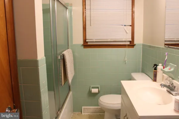 a white toilet sitting next to a bathroom sink and tub