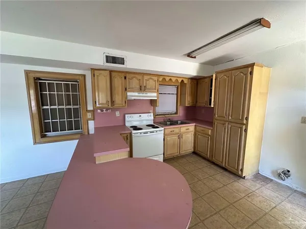 a kitchen with sink refrigerator and cabinets