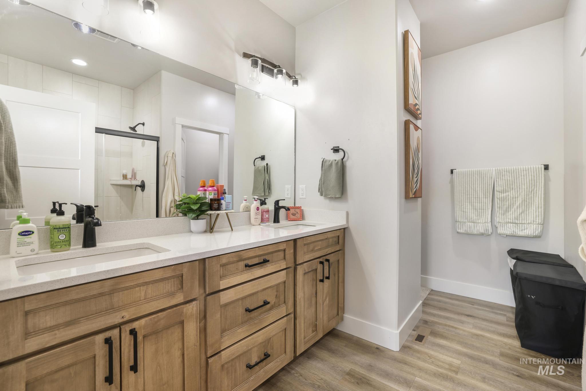 1231 Frank Henry Road Twin Falls, ID 83301 - Photo 19 of 48 Bathroom featuring double vanity, a stall shower, light wood-style flooring, and recessed lighting